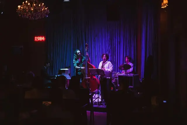 Concerto con il sax ospite in un locale illuminato di blu