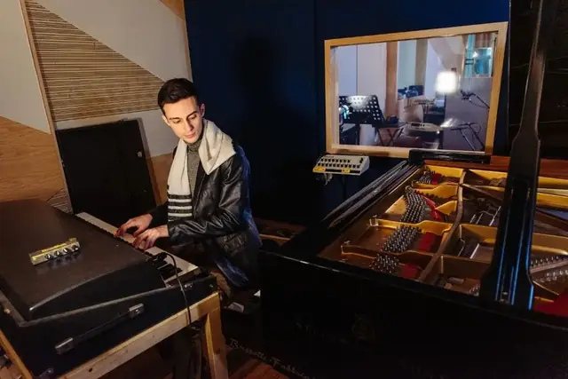 Francesco Negri alle tastiere accanto al pianoforte a coda