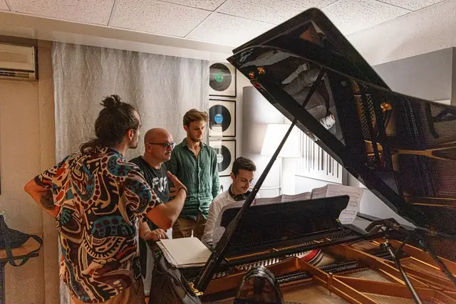 Il gruppo attorno al pianoforte durante la lavorazione dei brani